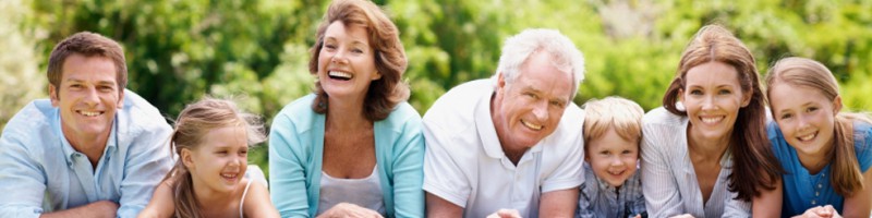 Smiling and happy family lying together on the grass outdoors